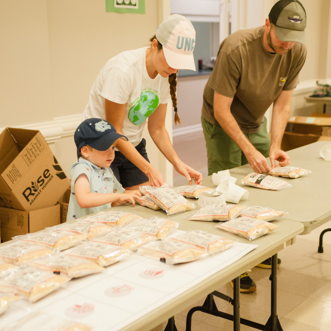 A family works together to organize food packets for Rise Against Hunger